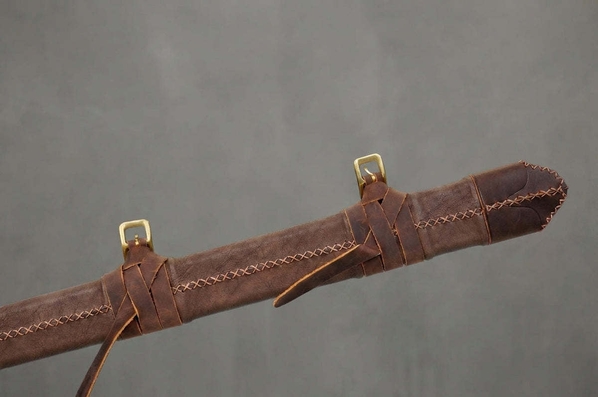 Stormbreaker Zweihänder : Scheidenmund aus braunem Leder mit Messingschnallen und Nähten vor grauem Betonhintergrund
